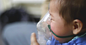 Niño con mascarilla de oxígeno, padeciendo el virus sincicial.