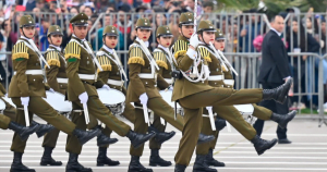 A la derecha, la tambor mayor liderando la banda de guerra de su institución. Foto: Carabineros TW.