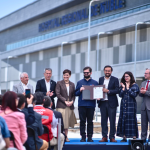 El mandatario y autoridades, tras la firma de un convenio de salud. Al fondo, el hospital. Foto: Presidencia.