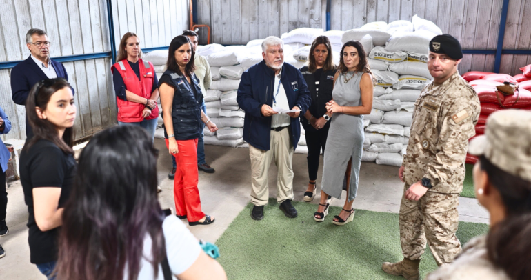 Al frente, autoridades del ámbito. Al fondo, parte de los alimentos donados. Foto: Ministerio.