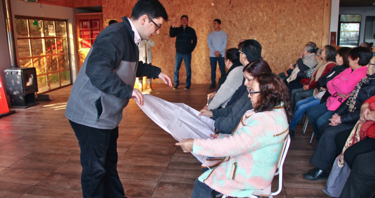 Un funcionario mostrando los planos a vecinas del sector. Foto: Municipio.